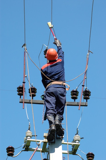 Elektryk mierzy napięcie na linii zasilającej przed zainstalowaniem uziemienia.