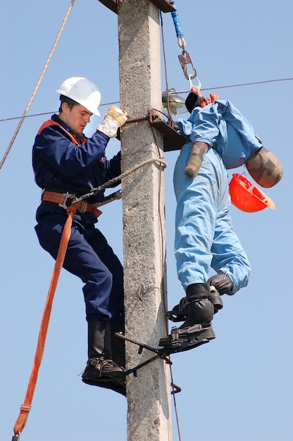 Elektryk pomaga pracownikowi porażonemu prądem. Trening na manekinie