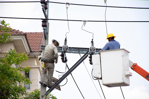 Elektryk pracownik Metropolitan Electricity Authority działa naprawa instalacji elektrycznej na słupie elektrycznym lub słupie energetycznym na 21 kwietnia 2018 r. w Bangkoku Tajlandia