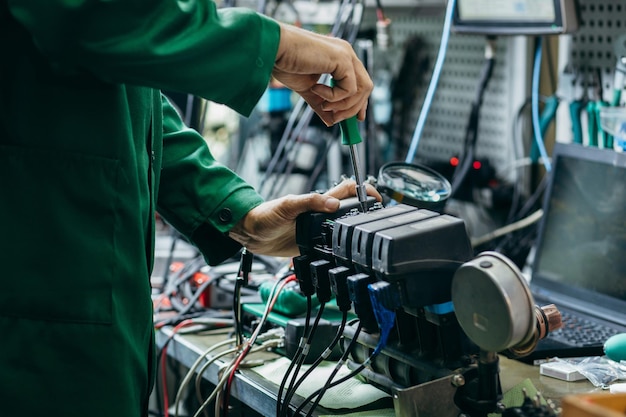 Elektryk sprawdza i naprawia zaworki rozpylacza hydraulicznego w warsztacie