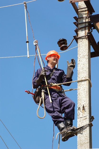 Elektryk wykonuje uziemienie na linii elektroenergetycznej