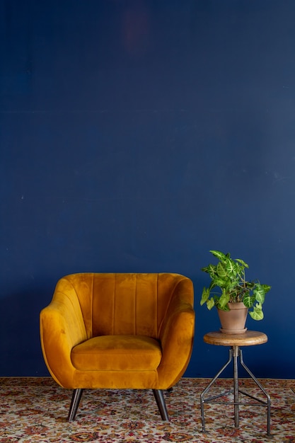 Element wnętrza żółty pusty fotel na tle niebieskiej ściany przestrzeni dla przestrzeni kopii tekstu