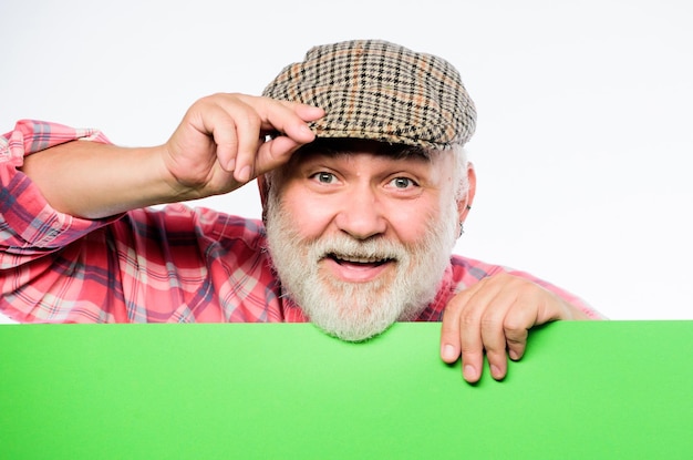Zdjęcie emeryt dziadek w vintage kapelusz trzymać plakat informacje kopia przestrzeń koncepcja ogłoszenia reklama sklep starszy brodaty mężczyzna zerknąć z banera miejsce ogłoszenie ogłoszenie zdarzenia