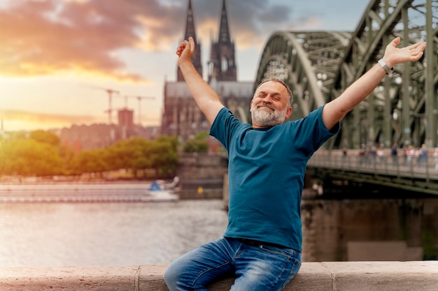 Emeryt podróżujący po Europie pociągiem brodaty mężczyzna siedzący na nabrzeżu Renu