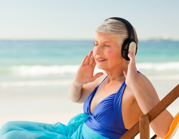 Emerytowana Kobieta Słucha Muzyka Przy Plażą