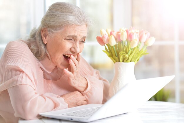 Emocjonalna starsza kobieta z laptopem