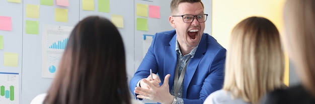 Emocjonalnie krzyczący trener biznesu prowadzi szkolenie pracowników, jak oprzeć się niegrzeczności głowy