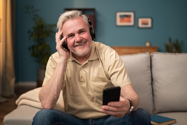 Energiczny starszy mężczyzna słucha nowej playlisty piosenek, starszy słucha przebojów radiowych