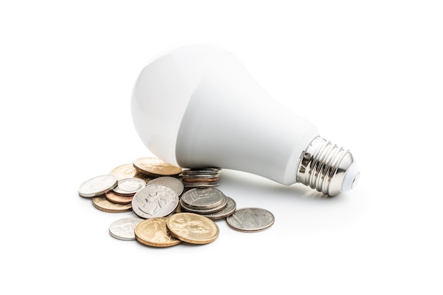 Energooszczędna żarówka i monety dolarowe izolowane na białym tle Żarówka LED