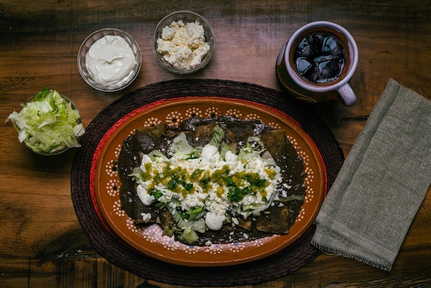 Enfrijoladas podawane w glinianym naczyniu Typowe jedzenie meksykańskie Tacos fasolowe ze śmietaną i serem