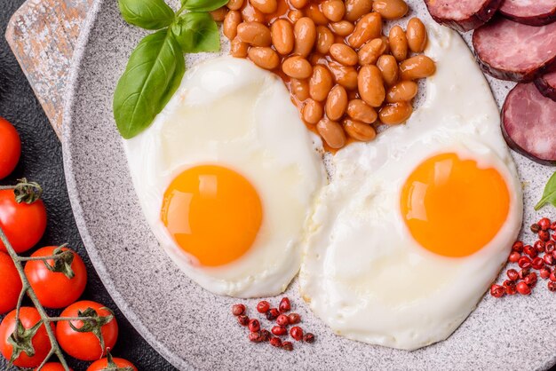 Zdjęcie english breakfast with fried eggs bacon beans tomatoes spices and herbs