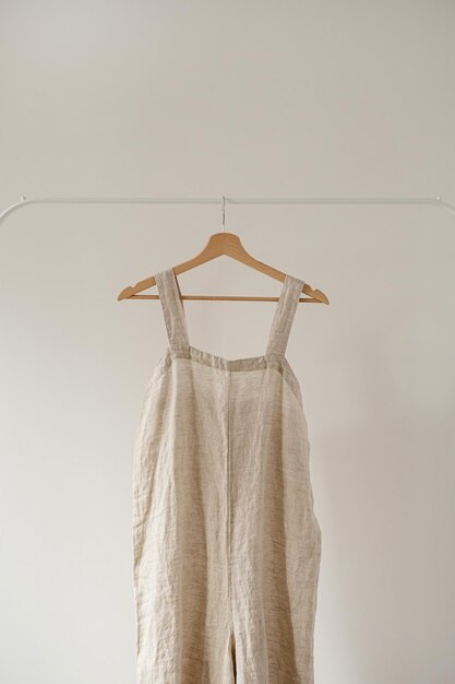 Estetyczna damska minimalistyczna koncepcja garderoby z neutralną pastelową beżową sukienką lub sukienką wykonaną ze spranego lnu na białym wieszaku Blog modowy strona społecznościowa