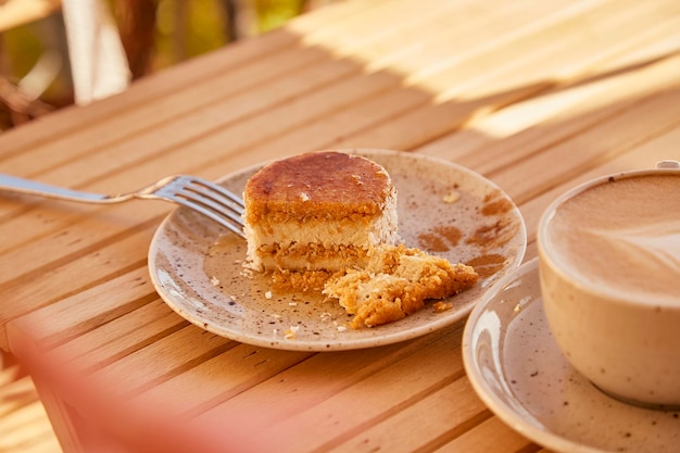 Estetyczny bezglutenowy bez pieczenia ciasto marchewkowe w twardych cieniach z filiżanką cappuccino