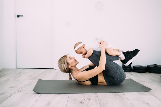 Europejska Blondynka Robi Fitness I ćwiczy W Domu Z Małym Dzieckiem Pojęcie Zdrowego Stylu życia I Gimnastyki