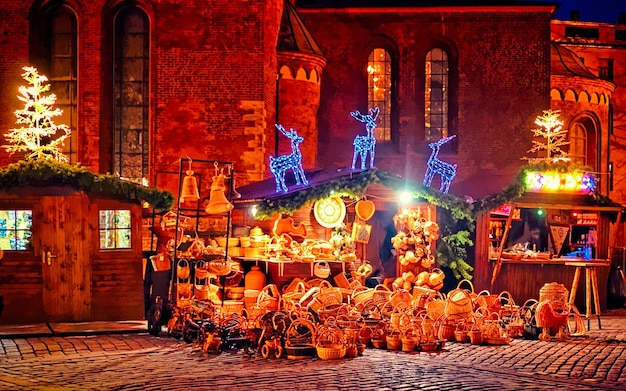Europejski rynek bożonarodzeniowy wieczorem Ryga Łotwa. Zima. Późnym wieczorem. Jarmark uliczny i świąteczny w europejskim mieście Dekoracja adwentowa z rękodziełem na bazarze