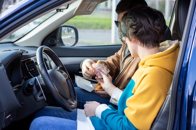 Facet I Dziewczyna Jedzą Hamburgery I Bryłki W Samochodzie Fast Food Niezdrowe Jedzenie