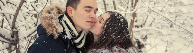 Facet i dziewczyna odpoczywają w zimowym lesie Mąż i żona na śniegu Młoda para