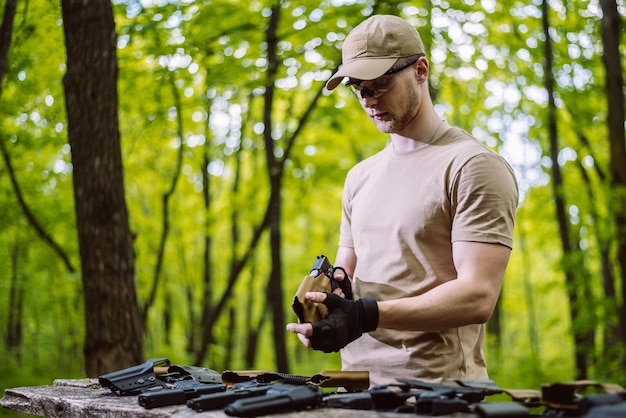 Facet w lesie testuje swoją broń do strzelaniny sportowej.