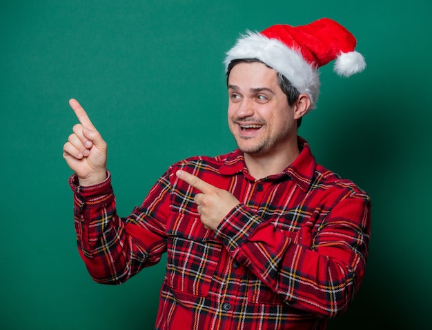 Facet w świątecznej czapce i koszuli w szkocką kratę na zielono