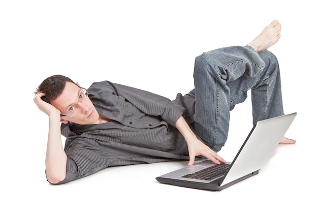 Zdjęcie facet z laptopem leży na podłodze na białym tle