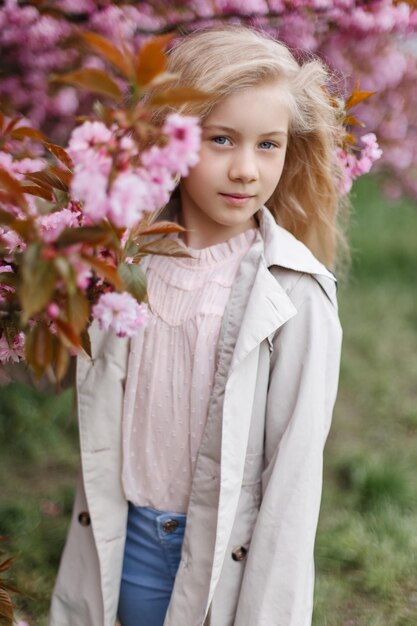 Fajna dziewczyna trzyma gałąź kwitnącej japońskiej sakura