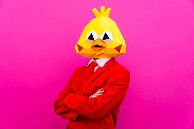 Fajny mężczyzna w masce 3d origami ze stylowymi kolorowymi ubraniami - kreatywna koncepcja reklamy, zwierzęca maska na głowie robi śmieszne rzeczy na kolorowym tle