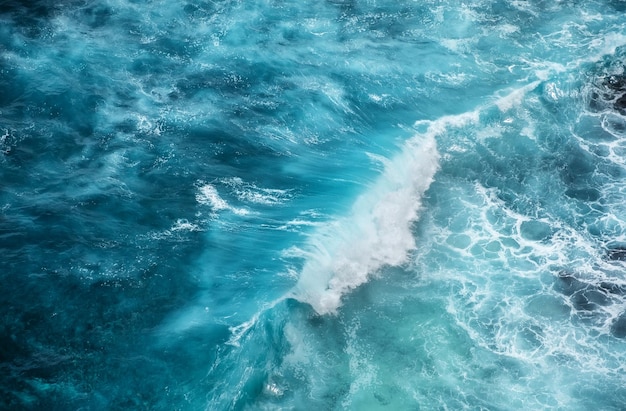 Fale i lazurowa woda jako tło Widok z wysokiej skały na powierzchni oceanu Naturalny letni pejzaż morski Tło wody