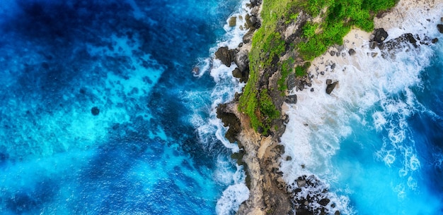 Fale i skały jako tło z widoku z góry Niebieskie tło wody z widoku z góry Letni pejzaż morski z powietrza Wyspa Bali Indonezja Obraz podróży