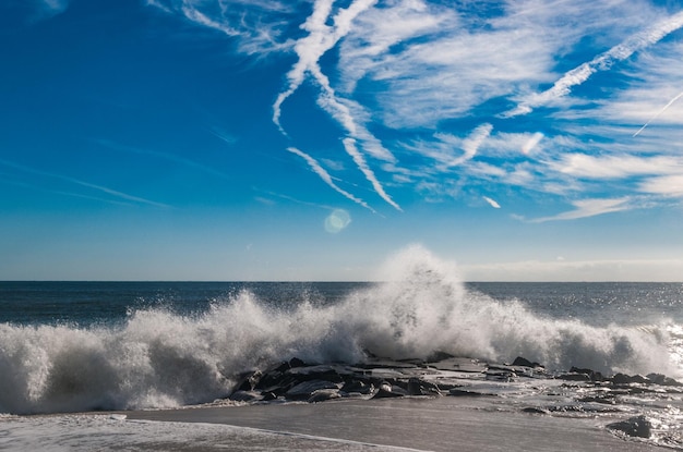 Zdjęcie fale rozbijające się na brzegu przeciwko niebu