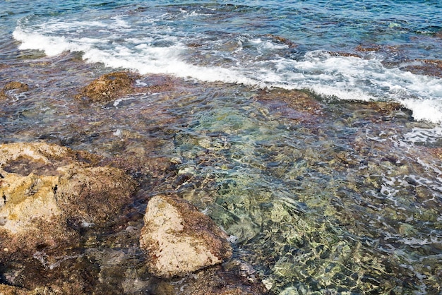 Fale upaść na skalistej plaży, tworząc odpryski Fale i powitalny na plaży