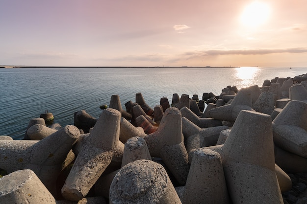 Falochrony czworonogów w wodzie morskiej. Piękny zmierzchu seascape z betonowymi tetrapodes