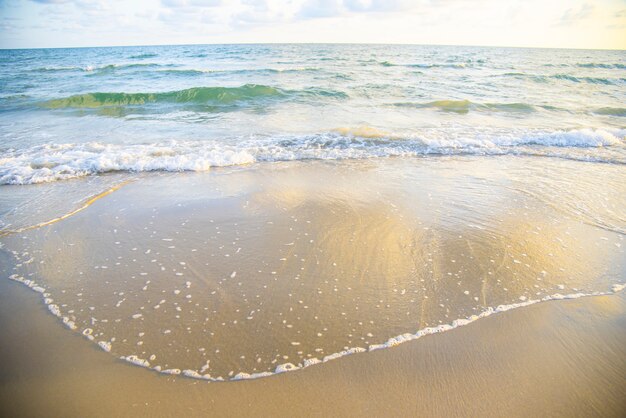 Falowy plażowy tła morze i piaskowaty piękny błękitny ocean