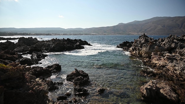 Fantastyczny widok na skaliste wybrzeże z pięknymi falami w Grecji, Kreta. W tle piękna góra i zatoka Balos.