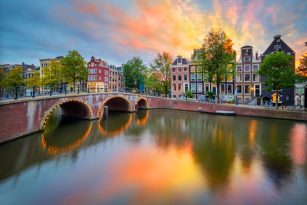 Fantastyczny zachód słońca zachód słońca wschód słońca kolory w Amsterdamie Panoramiczne widoki słynnych starych domów most i kanał w centrum Amsterdamu Holandia Holandia Europa