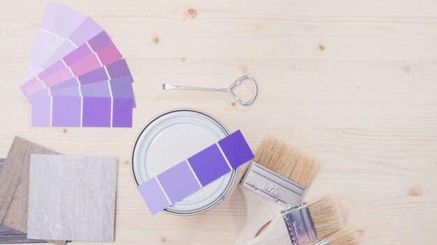 Farba metalowa może z fioletową farbą i innymi narzędziami do malowania do projektu majsterkowania.