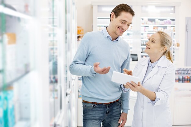 Farmaceuta pomaga przystojnemu mężczyźnie