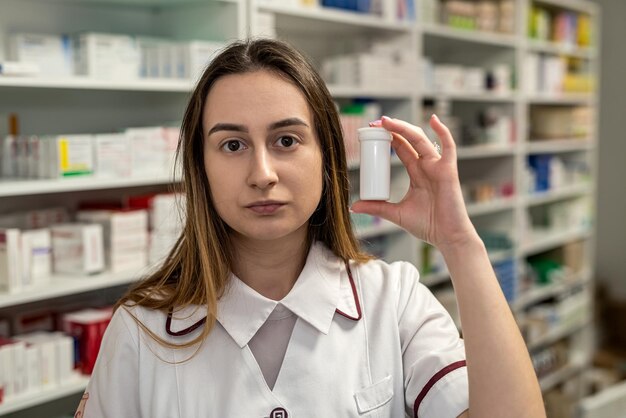 Zdjęcie farmaceuta trzyma w dłoniach wiele leków i układa je na półkach