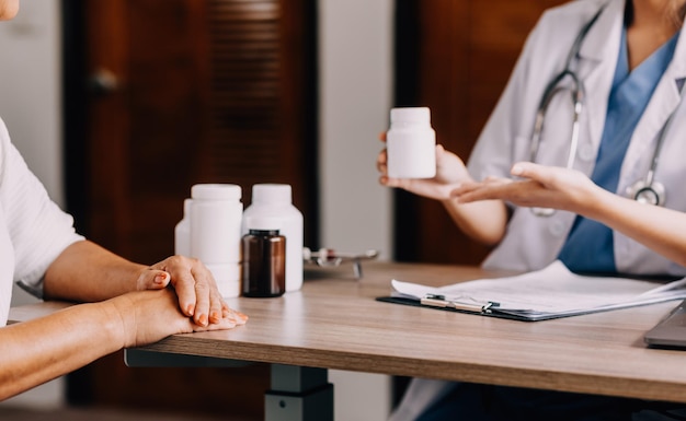 Farmaceuta wyjaśnia kobiecie w aptece leki na receptę dotyczące leczenia farmaceutycznego Lada lekarska i aptekarka rozmawiają z pacjentem na temat leków w przychodni