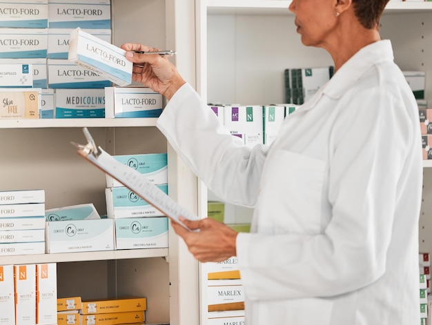 Farmaceutka i inspekcja zapasów tabletek lub leków na półce w aptece Kobieta pracująca w służbie zdrowia lub lekarzu sprawdzająca zapasy lub produkty farmaceutyczne w aptece