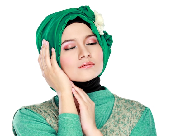 Fasonuje portret młoda piękna muzułmańska kobieta jest ubranym hijab z zielonym kostiumem