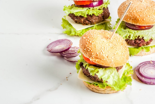 Fast Food. Niezdrowe Jedzenie. Pyszne świeże Smaczne Hamburgery Z Kotletem Wołowym, świeżymi Warzywami I Serem Na Białym Tle. Copyspace