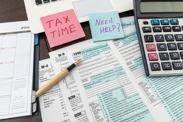 Federalny formularz podatkowy 1040 z naklejką, kalkulatorem i długopisem. Dokumenty finansowe.