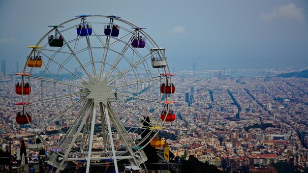 Zdjęcie ferris wheel przeciwko miastu