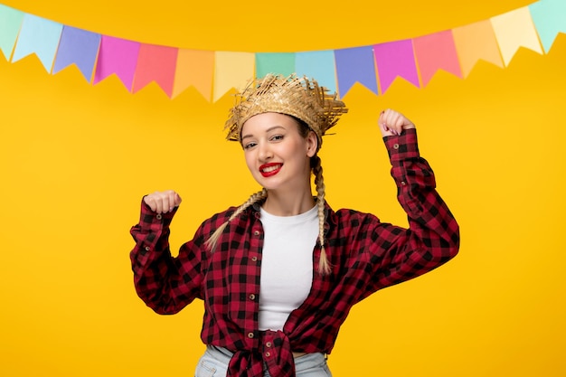 Zdjęcie festa junina blond śliczna dziewczyna w słomkowym kapeluszu brazylijski festiwal z kolorowymi flagami tańczącymi