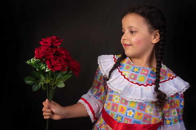 Festa junina w Brazylii, brazylijska dziewczyna z warkoczami i ubrana na imprezę junina z bukietem kwiatów w dłoni.