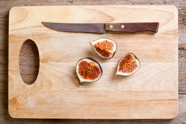Figi i stary nóż na drewnianej desce