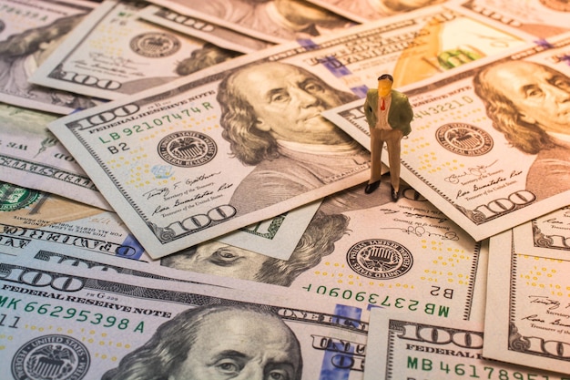 Figurka człowieka na banknotach dolarów amerykańskich jako koncepcja biznesowa