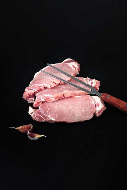 Filet z surowego mięsa cielęcego do grillowania z widelcem do mięsa na ciemnym tle Filet z polędwicy wołowej mignon