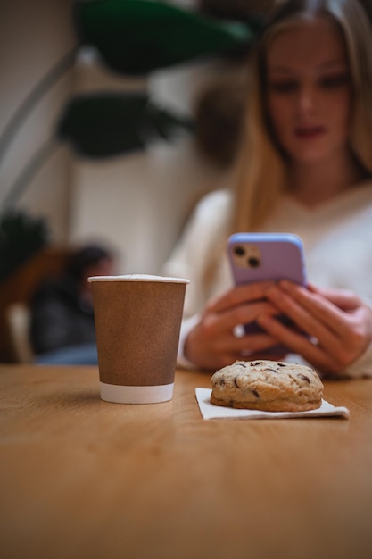 Filiżanka do cappuccino i czekoladowe ciastko fotografowane przez dziewczynę dla jej mediów społecznościowych