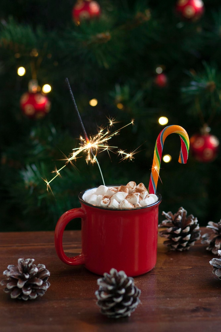 Zdjęcie filiżanka gorącego napoju z marshmallow i cukierkiem i świąteczne oświetlenie